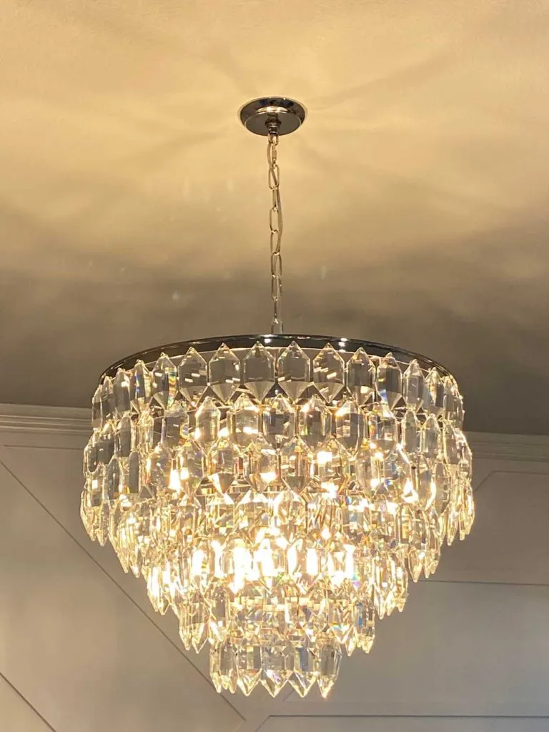 A crystal chandelier installed and lit in a home