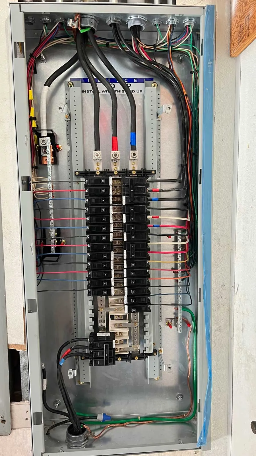 An open residential breaker panel with neat, labeled wiring