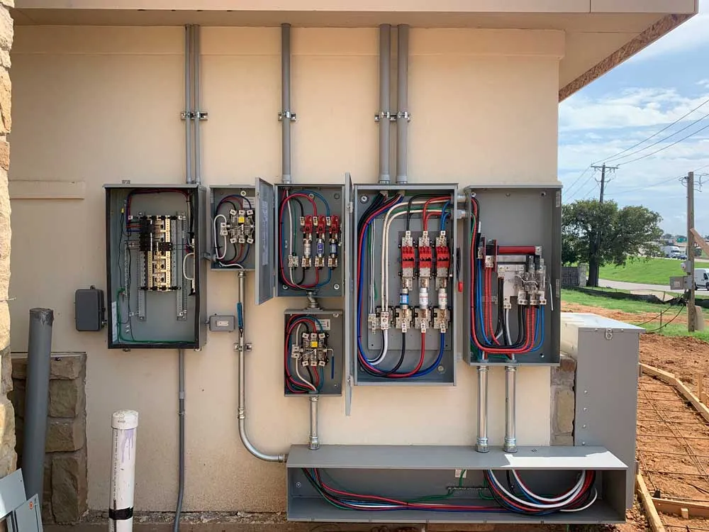 A wall of electric meters and disconnects with new conduit